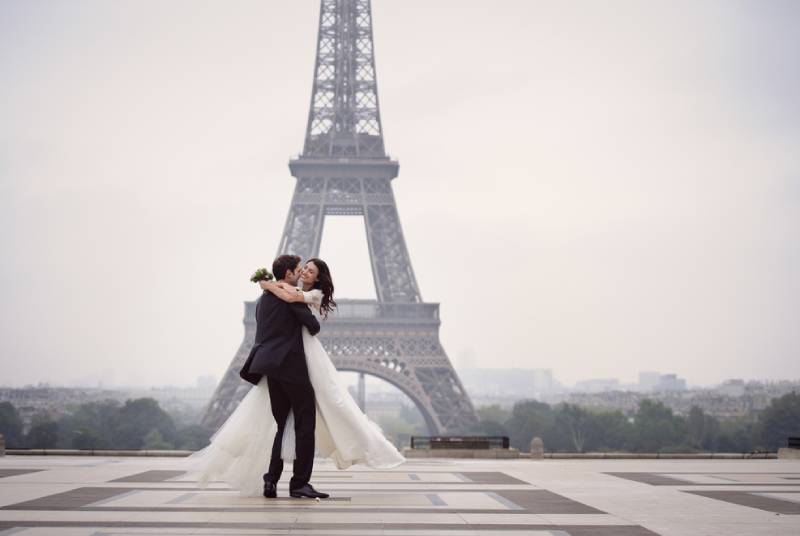 Braut und Bräutigam haben einen romantischen Moment an ihrem Hochzeitstag in Paris
