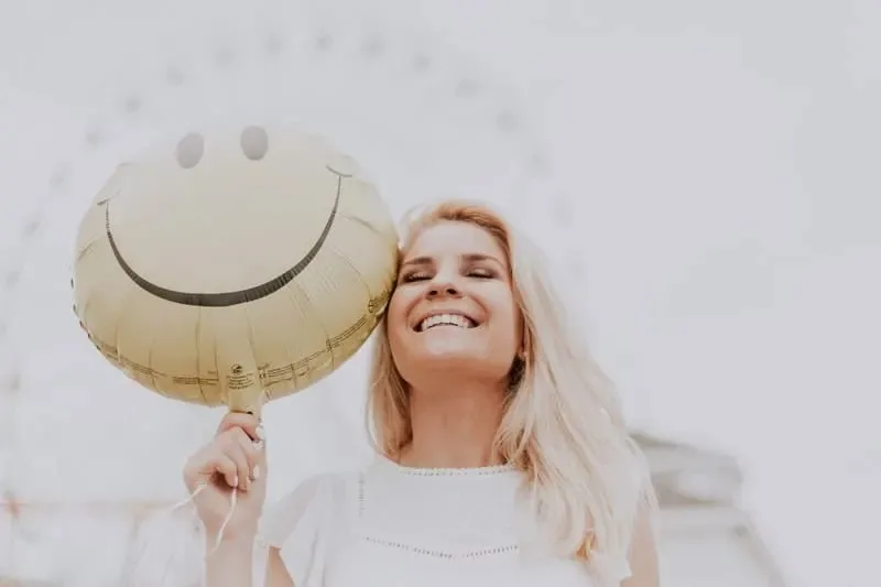 Frau mit Smiley-Ballon
