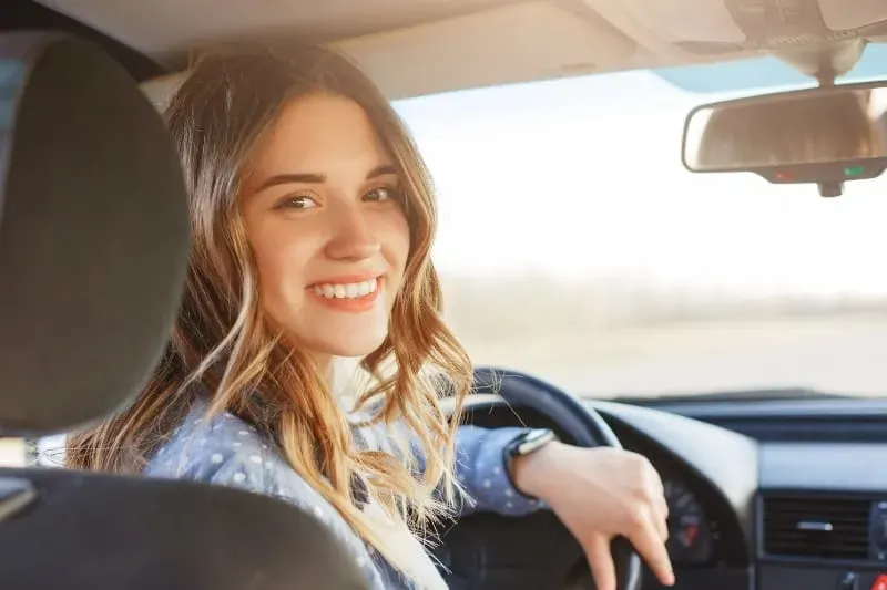 laechelnde Frau im Auto