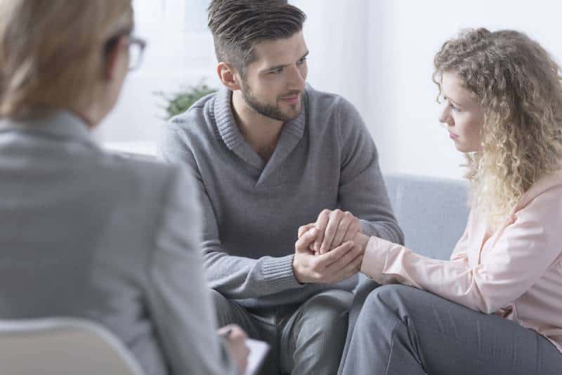 Ehemann entschuldigt sich bei seiner Frau während der Paartherapie