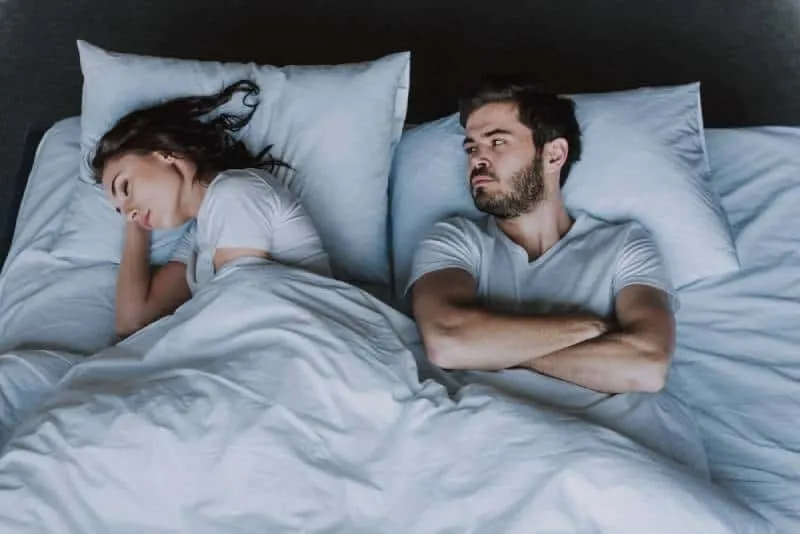 wuetender Mann im Bett mit Frau