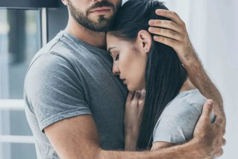 Ein Mann umarmt eine traurige Frau