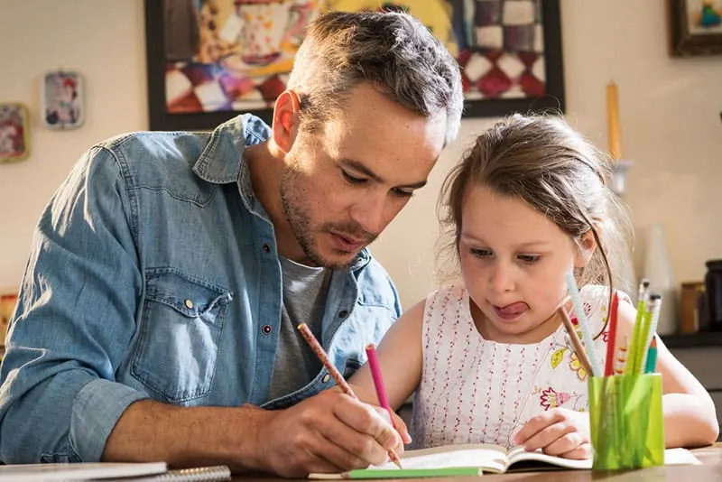 Ein Vater hilft seiner Tochter bei den Hausaufgaben
