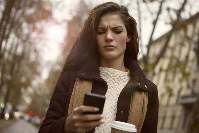 Ein wütendes Mädchen schaut auf das Telefon