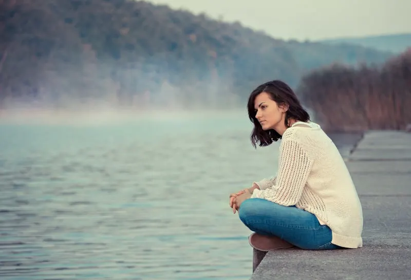Eine Frau sitzt am See