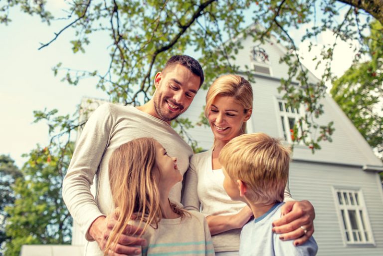 glückliche Familie, die vor Haus steht