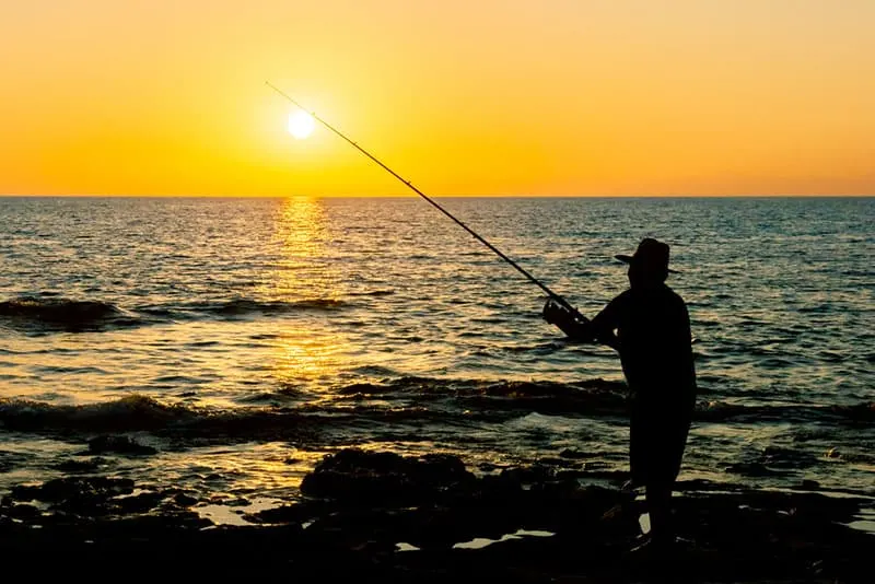 Fischer bei Sonnenuntergang angeln