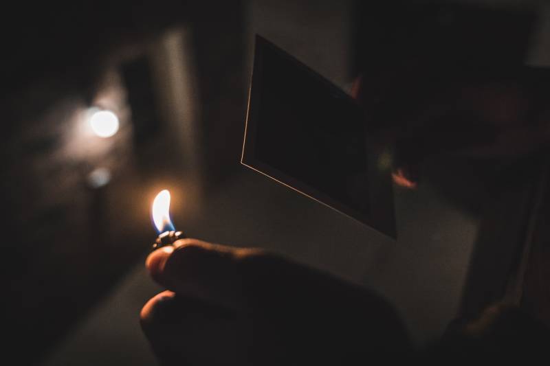 Fotografie mit flachem Fokus einer Person, die ein Feuerzeug hält