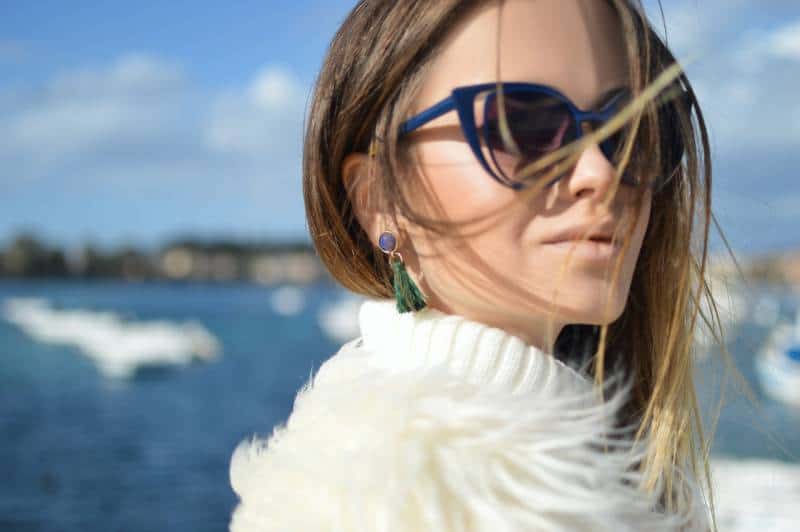 Frau, die blau gerahmte Cat-Eye-Sonnenbrille mit Gewässerhintergrund trägt
