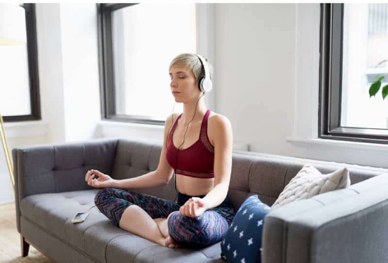 Frau, die eine Meditations-App als Teil ihrer Morgenroutine der Achtsamkeit hört