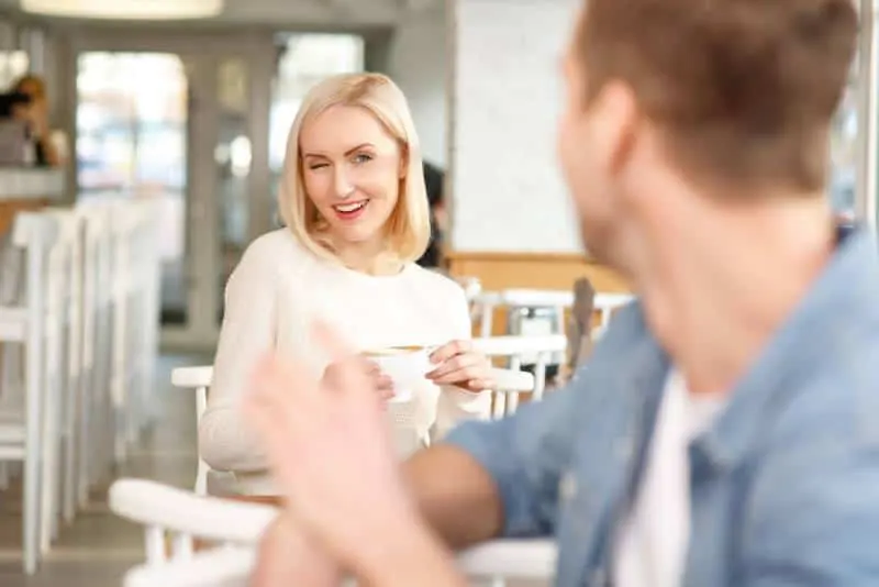 Frau flirtet mit Mann in Kaffeebar