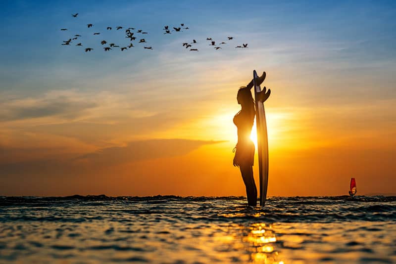 Frau hält Surfbrett auf dem Meer