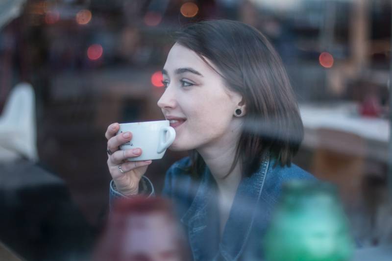 Frau hält weiße Keramik Teetasse