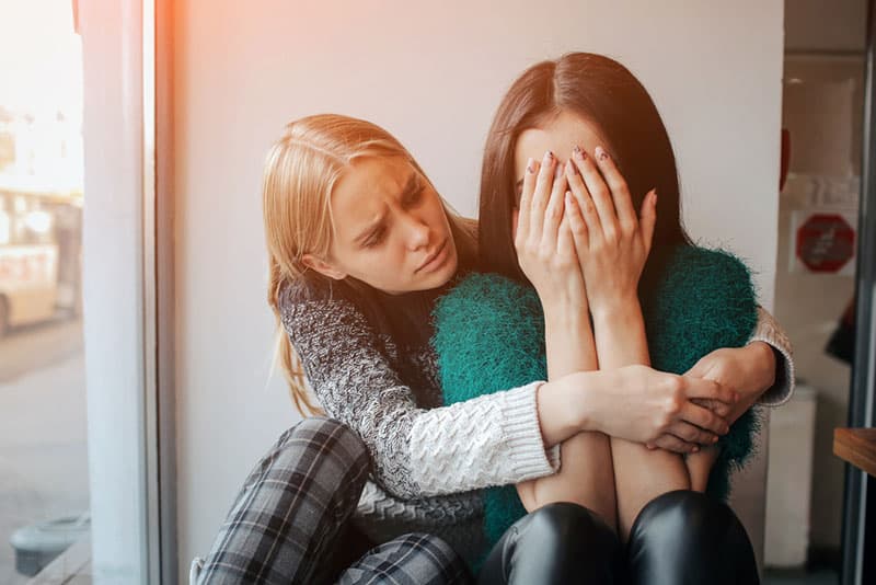 Frau tröstet eine andere Frau