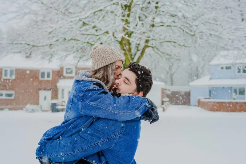 Mann und Frau umarmen auf Schneefeld