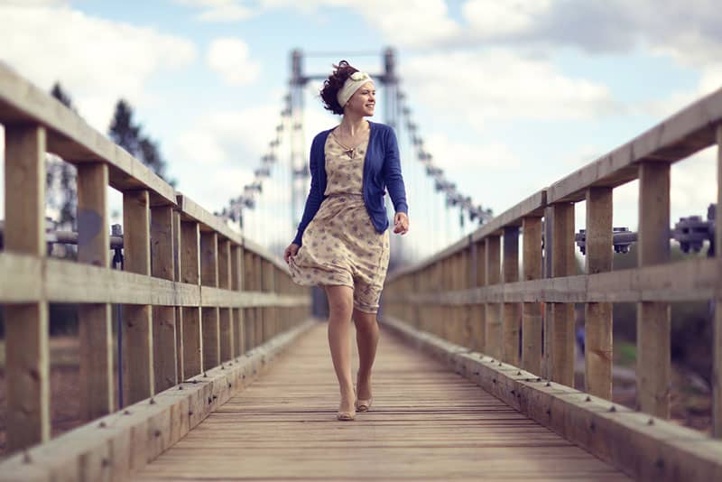 Frauen im Kleid gehen über die Brücke