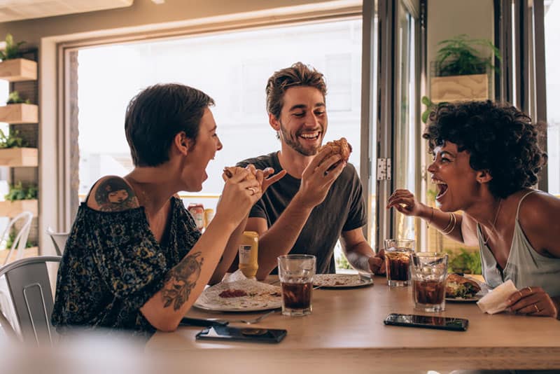 Geschwister essen zusammen zu Mittag und lachen