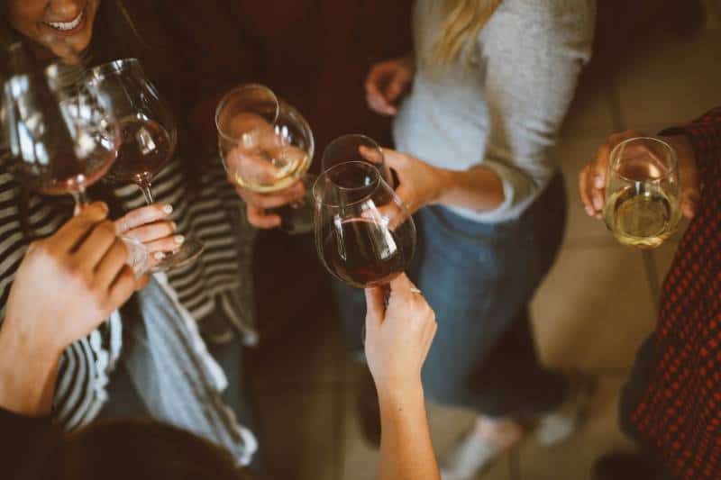 Gruppe von Freunden jubeln mit Gläsern Wein