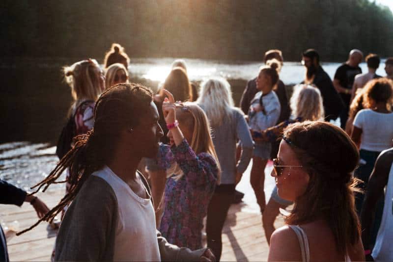 Gruppe von Menschen, die auf dem Dock neben dem Gewässer stehen