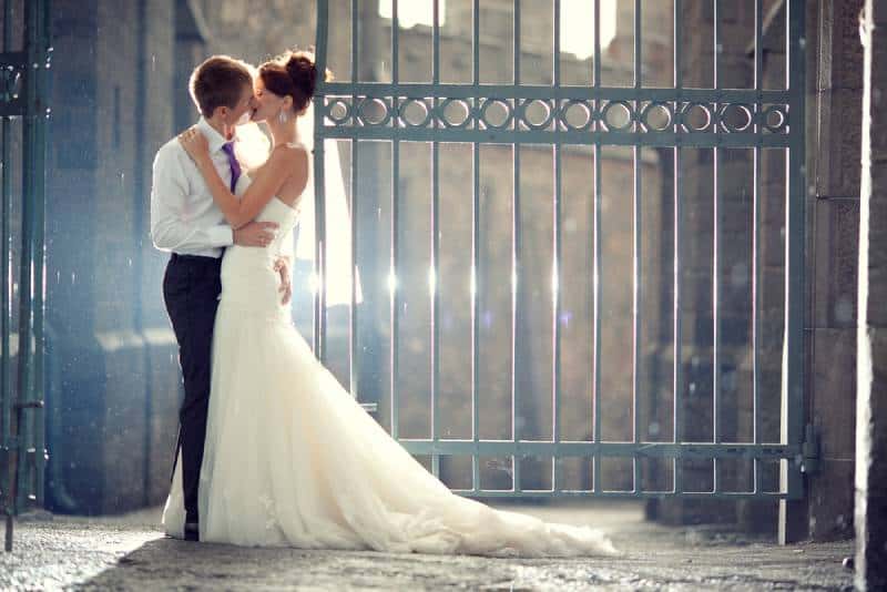 Hochzeitspaar Umarmungen und Küsse am Tor