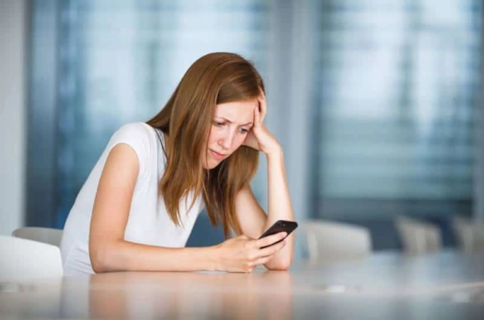 Besorgte Frau schaut auf Mobiltelefon