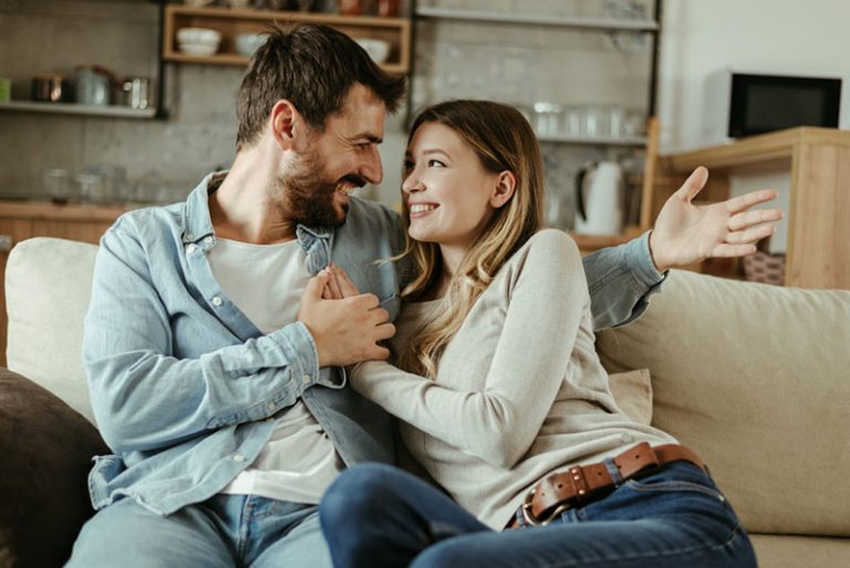 glückliches Paar, das auf Sofa kuschelt