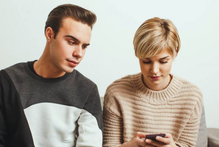 eifersüchtiger Mann, der Frauentelefon betrachtet