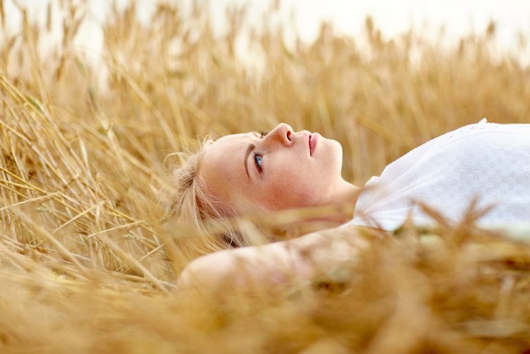 blonde Frau, die auf dem Feld liegt
