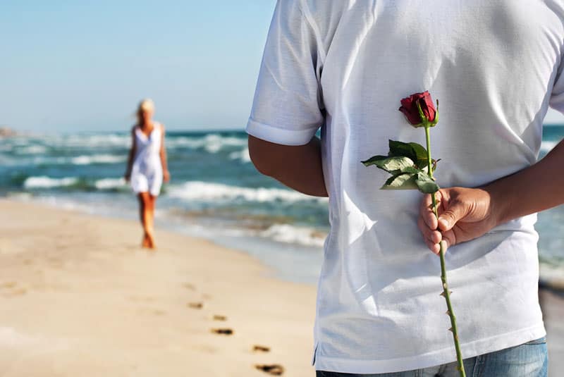Mann hält eine Rose für seine Frau
