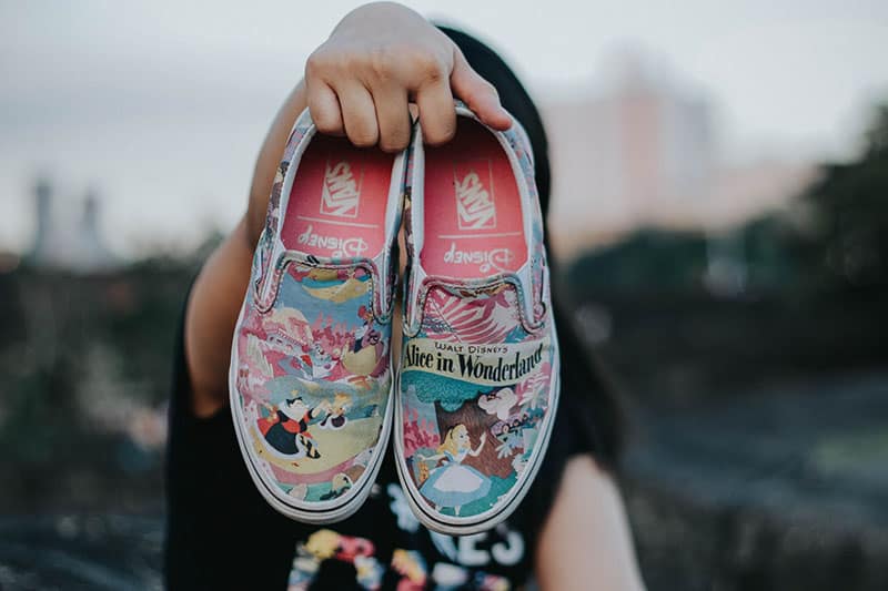 Mann hält Schuhe von Disney