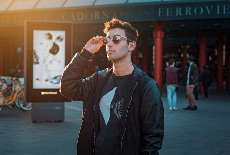 Mann in schwarzer Reißverschlussjacke mit Sonnenbrille