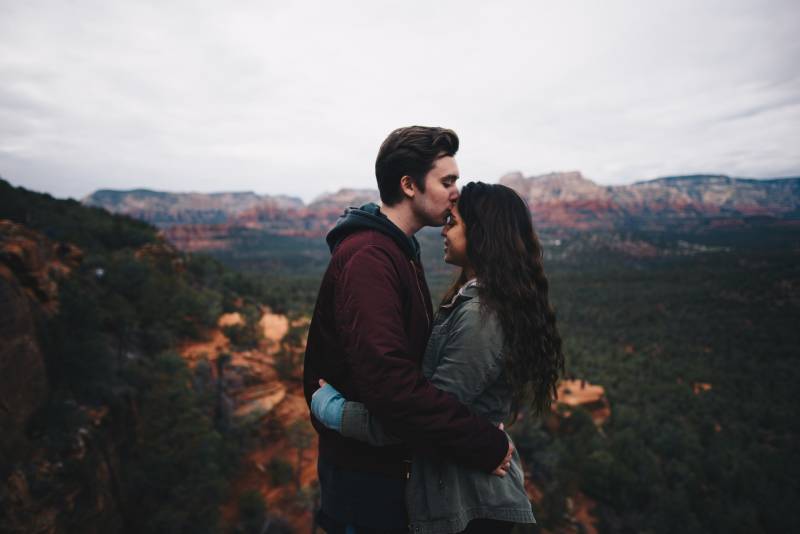Mann küsst ihr Mädchen Stirn in der Natur