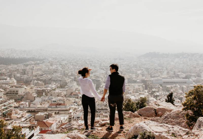 Mann und Frau auf dem Hügel halten ihre Hände
