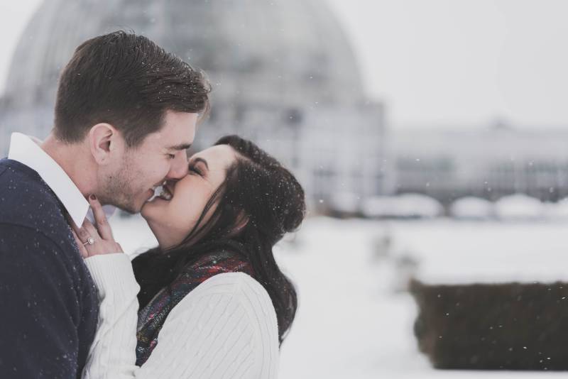 Mann und Frau küssen sich im Schneewetter