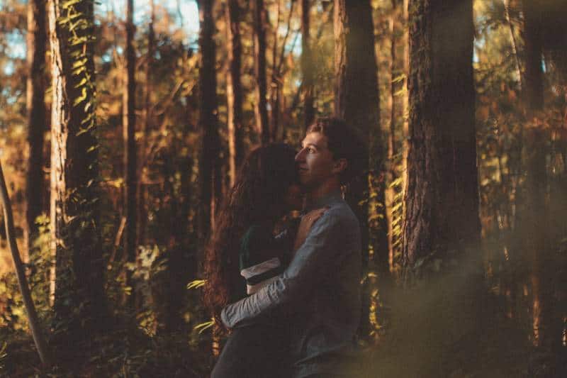Mann und Frau umarmen sich auf Wald