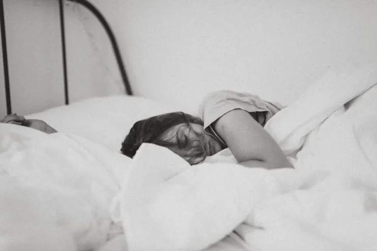 Frau schlaeft im Bett