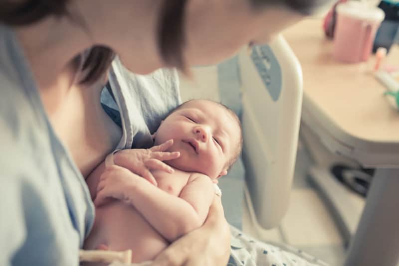 Mutter hält Neugeborenes Baby