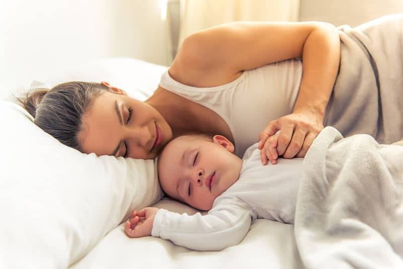Mutter schläft mit ihrem Baby