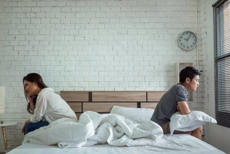 Paare streiten sich im Bett, sie argumentieren, nicht miteinander zu reden