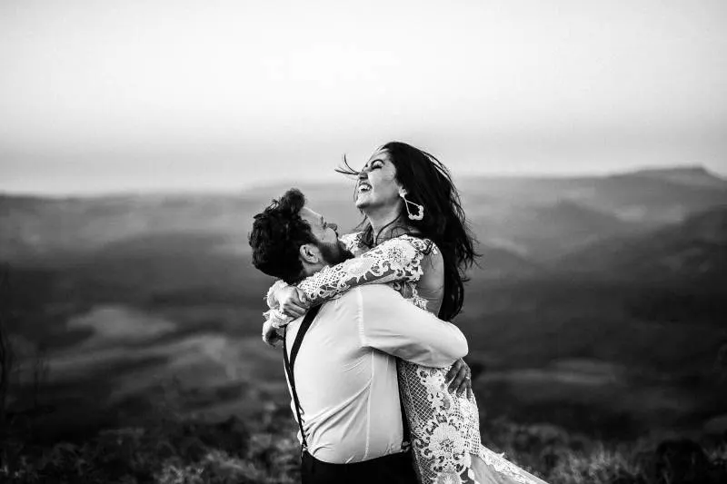 Graustufenfotografie von Mann und Frau, die nahe Hügel umarmen