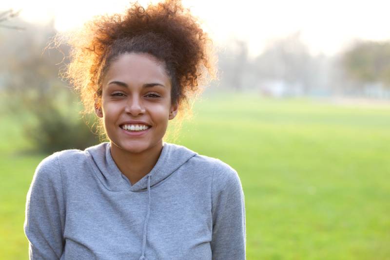 Porträt einer lächelnden jungen Afroamerikanerfrau im Freien