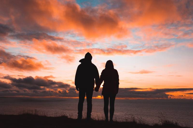 Silhouette Foto von Mann und Frau auf Klippe