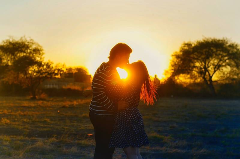 Silhouette Fotografie des Paares, das in der Mitte des Feldes küsst