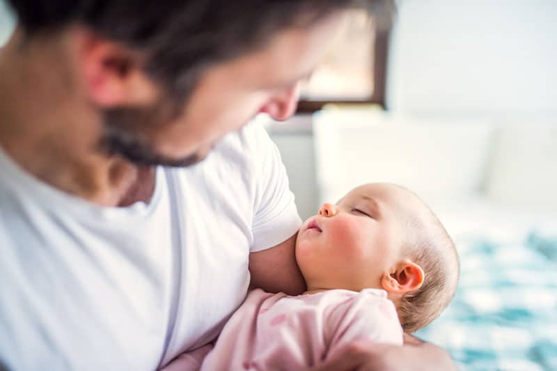 Vater hält ihre kleine Tochter im Schlaf