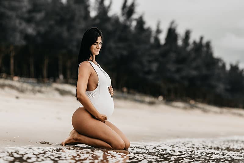 attraktive schwangere Frau im Badeanzug
