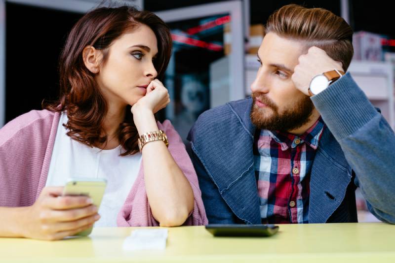 besorgtes Paar, das sich im Café ansieht