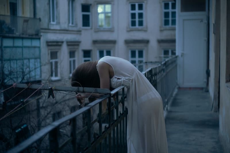 eine Frau, die sich über einen Zaun beugt