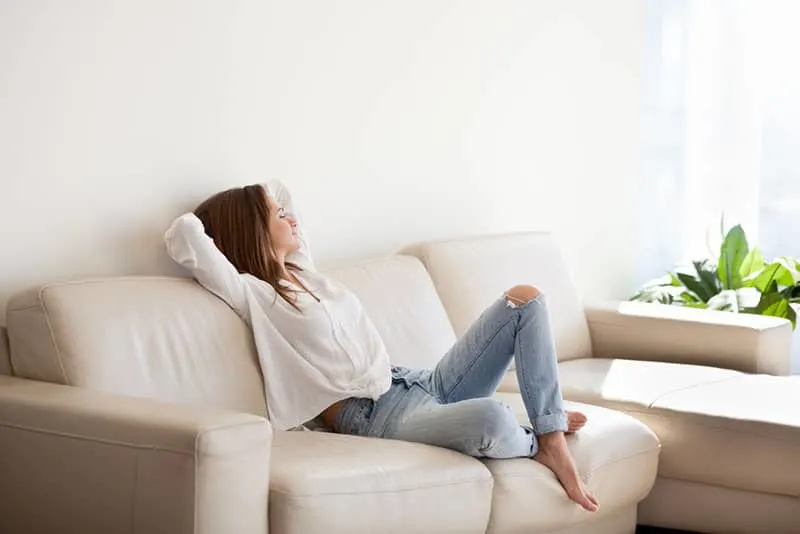entspannte Frau sitzt auf dem Sofa