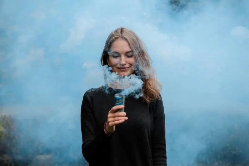 flache Fokusfotografie der Frau, die durch Rauch umgeben wird