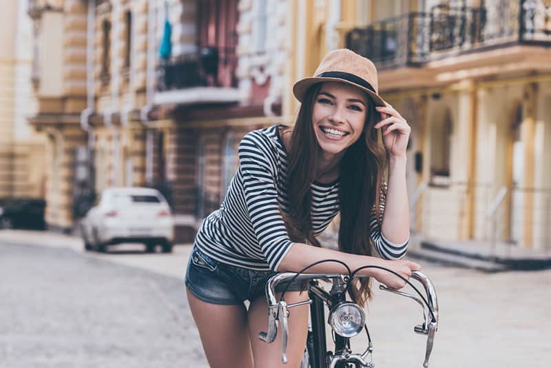 glückliche Frau, die mit Fahrrad aufwirft